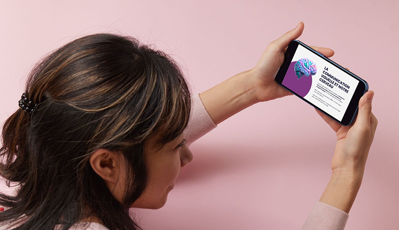 Jeune femme tenant un smartphone affichant la formation de méthode impact pour la communication visuelle.
